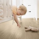 Baby Girl Reaching out of Crib to get Stuffed Toy
